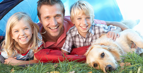 Young father poses with children in tent