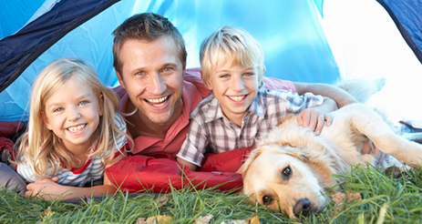 Young father poses with children in tent