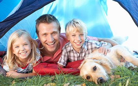 Young father poses with children in tent