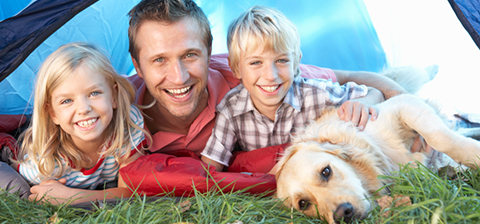 Young father poses with children in tent