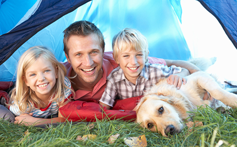 Young father poses with children in tent