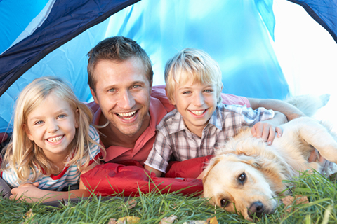 Young father poses with children in tent